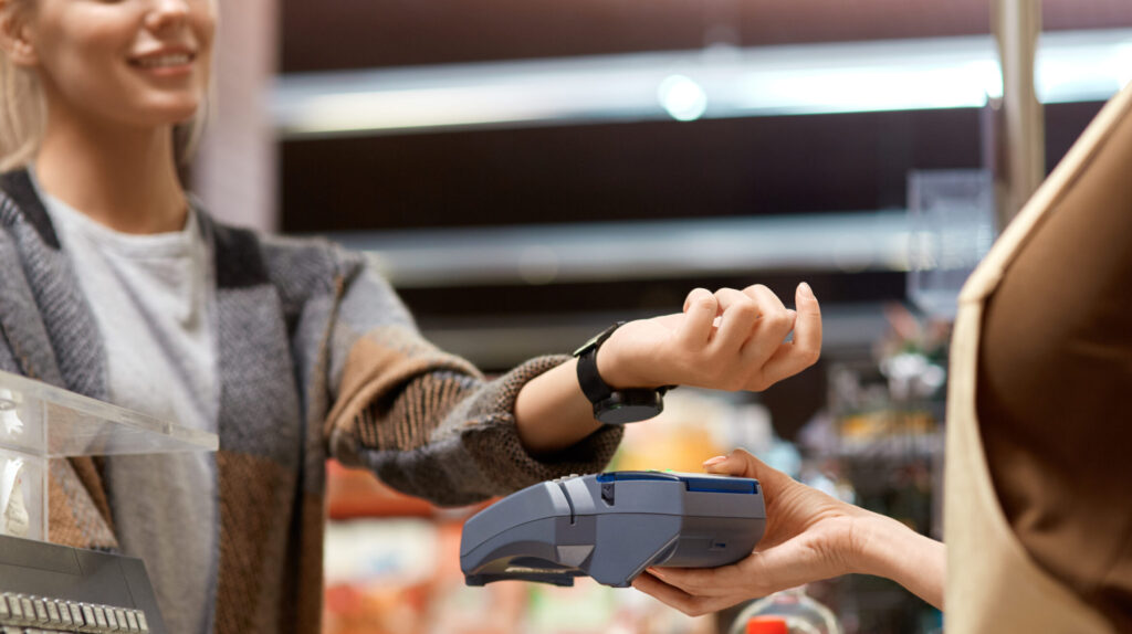 Una mujer paga con su reloj la compra del supermercado utilizando la tecnología contactless.