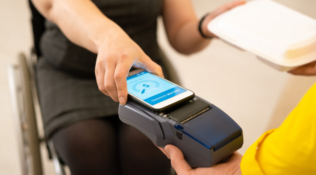 Una mujer procede a pagar a un repatidor usando su teléfono.