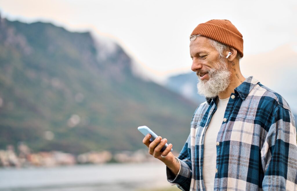 Un señor consulta su móvil mientras escucha música.