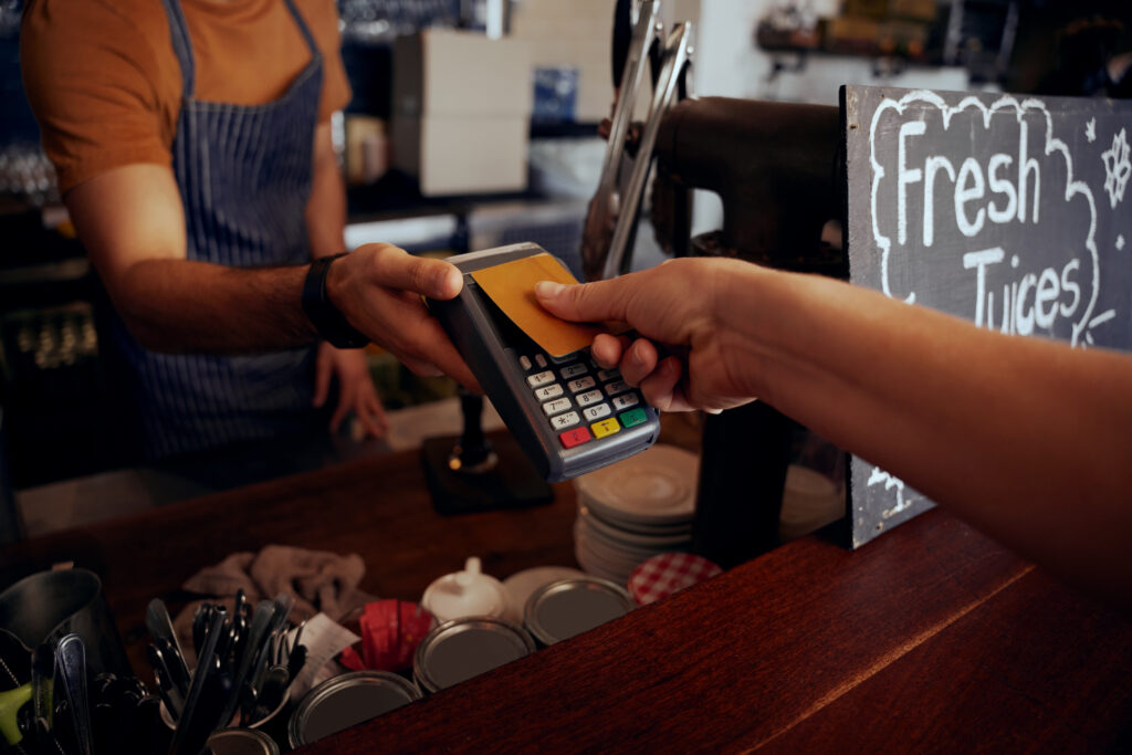 Una persona realiza un pago contactless con su tarjeta del banco en un comercio.